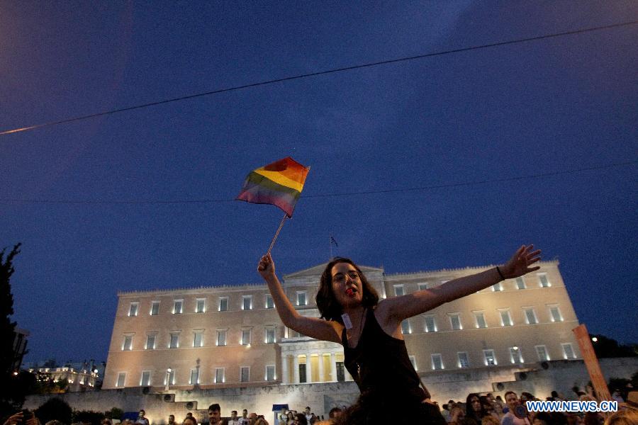 A protester waves a rainbow flag during an annual Gay Pride rally in Athens, Greece, June 13, 2015.