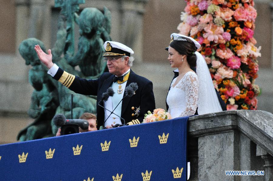 Sweden's King Carl XVI Gustaf (L) greets the people with Sweden's Prince Carl Philip and Princess Sofia after their wedding ceremony at Stockholm Palace in Stockholm, Sweden, June 13, 2015.