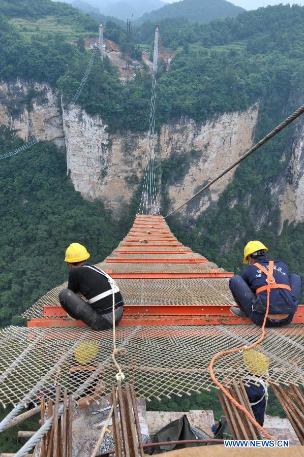 Workers build the vitreous bridge above the grand canyon in Zhangjiajie, central China's Hunan Province, June 15, 2015.