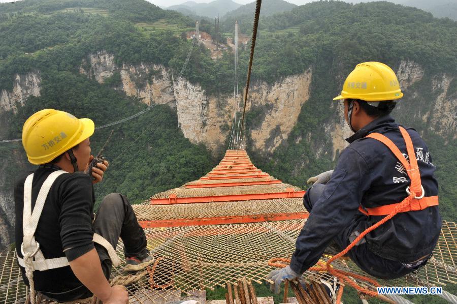 Workers build the vitreous bridge above the grand canyon in Zhangjiajie, central China's Hunan Province, June 15, 2015. 