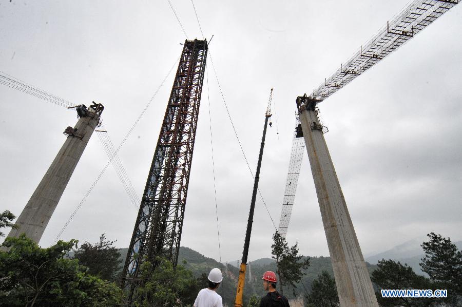 Workers build the vitreous bridge above the grand canyon in Zhangjiajie, central China's Hunan Province, June 15, 2015.