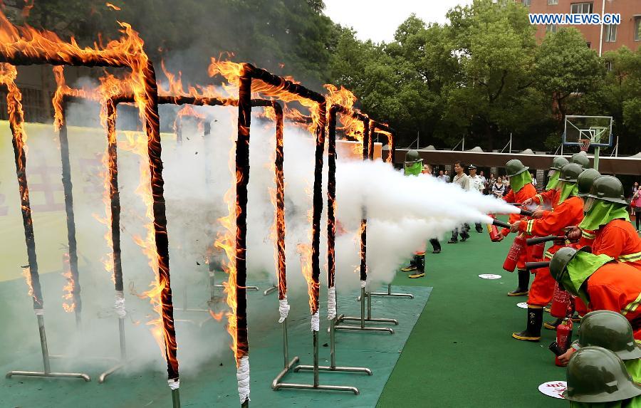 Students put out fire during a fire drill at Nanhu Vocational School in the Hongkou District of Shanghai, east China, June 15, 2015.