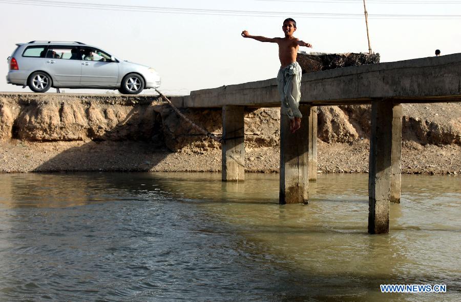 An Afghan boy jumps into a canal in Kandahar province, southern Afghanistan, June 15, 2015.