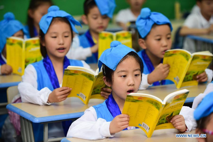 Pupils wearing traditional costumes read classic poetry in an event to learn Duanwu customs at Cuitingyuan Elementary School in Hefei, capital of east China's Anhui Province, June 16, 2015.