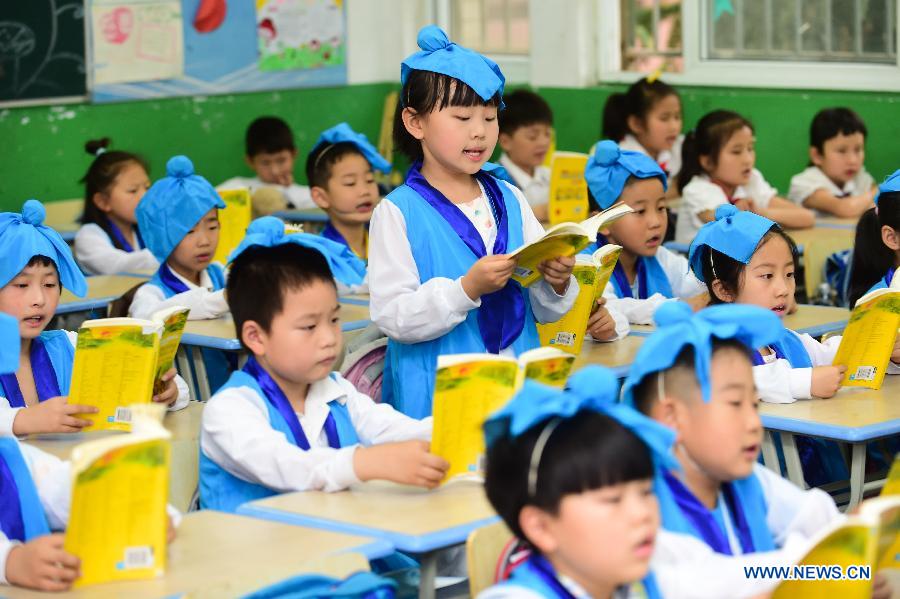 Pupils wearing traditional costumes read classic poetry in an event to learn Duanwu customs at Cuitingyuan Elementary School in Hefei, capital of east China's Anhui Province, June 16, 2015.