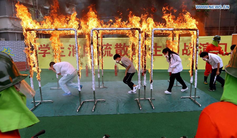 Students attend a fire drill at Nanhu Vocational School in the Hongkou District of Shanghai, east China, June 15, 2015. 