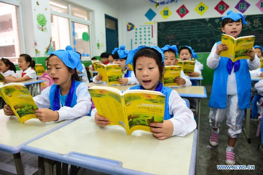 Pupils wearing traditional costumes read classic poetry in an event to learn Duanwu customs at Cuitingyuan Elementary School in Hefei, capital of east China's Anhui Province, June 16, 2015. 