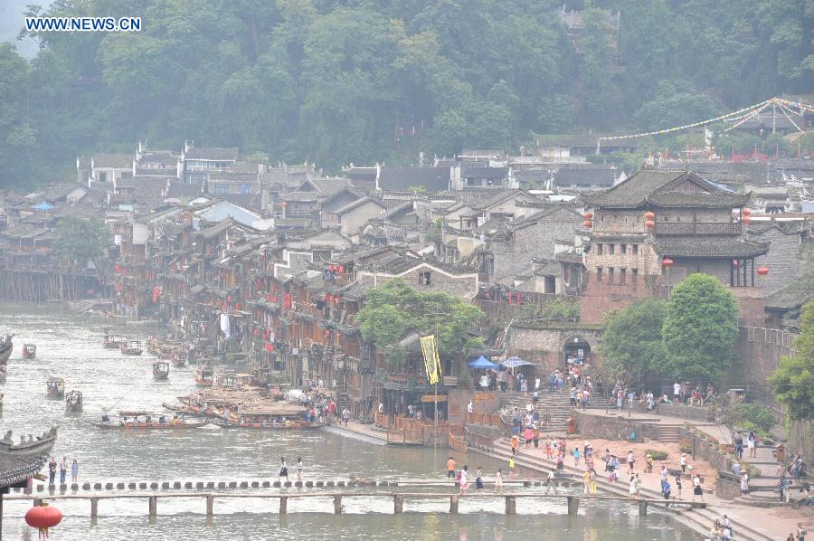 Photo taken on June 17, 2015 shows the ancient town of Fenghuang shrouded in fog in central China's Hunan Province. 