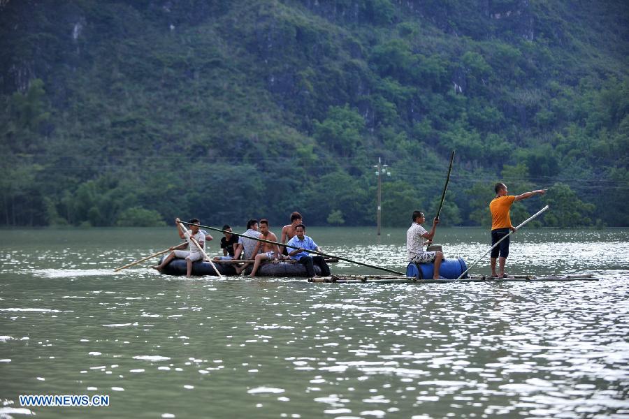 Residents row a self-made rafts at the flooded Longchang Village in Mashan County, southwest China's Guangxi Zhuang Autonomous Region, June 16, 2015.