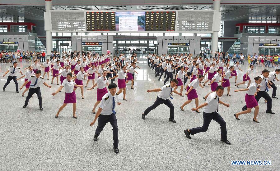 More than 100 attendants dance at the Guiyang North Railway Station in Guiyang, capital of southwest China's Guizhou Province, June 17, 2015.