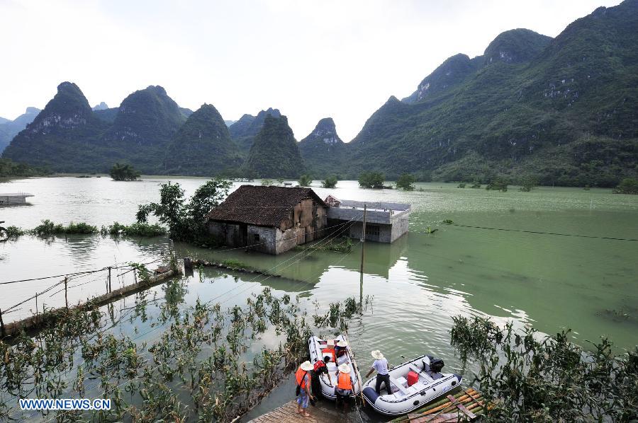 Rescuers transport relief materials to residents at the flooded Longchang Village in Mashan County, southwest China's Guangxi Zhuang Autonomous Region, June 16, 2015. 