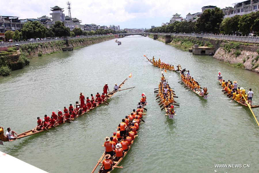 Competitors row dragon boats during a race held on the Xiaoshuihe River to celebrate the coming Dragon Boat Festival in Yongzhou, central China's Hunan Province, June 16, 2015. 