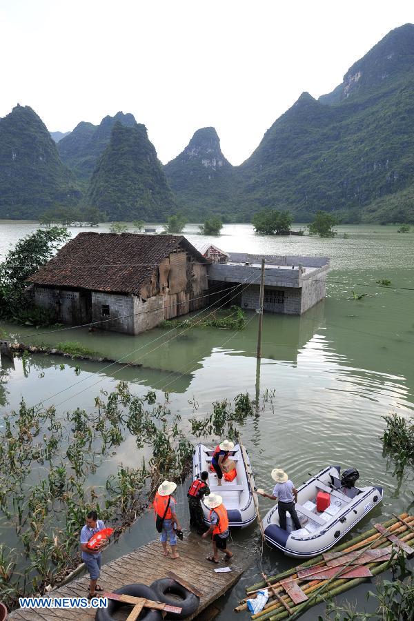 Rescuers transport relief materials to residents at the flooded Longchang Village in Mashan County, southwest China's Guangxi Zhuang Autonomous Region, June 16, 2015. 