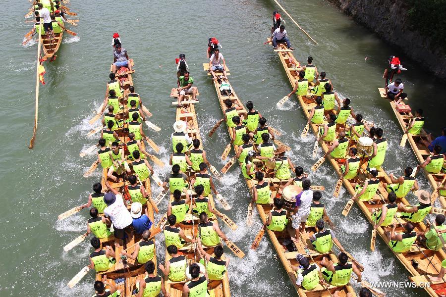 Competitors row dragon boats during a race held on the Xiaoshuihe River to celebrate the coming Dragon Boat Festival in Yongzhou, central China's Hunan Province, June 16, 2015.