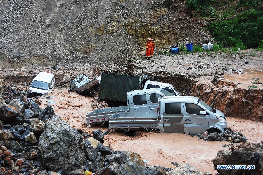 Motorcars are washed to the Longtangou River by torrents triggered by heavy rainfall in Wushan County, southwest China's Chongqing Municipality, June 16, 2015.