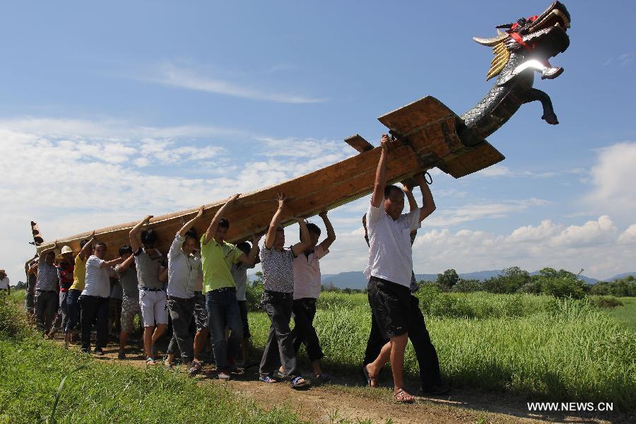 People carry their dragon boat for a race held on the Xiaoshuihe River celebrating the coming Dragon Boat Festival in Yongzhou, central China's Hunan Province, June 16, 2015. 