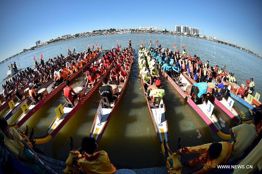 Participants wait for the start of a dragon boat competition in Chengmai, a county in south China's Hainan Province, on June 18, 2015. 