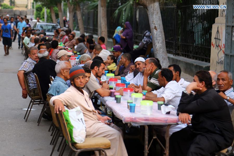 Egyptians wait for breaking their fast at a charity banquet offered to the poor in Cairo, Egypt, on June 22, 2015. 