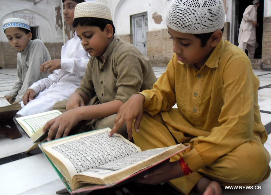 Pakistani Muslim boys read the holy book of Quran during Muslims fasting month of Ramadan at a mosque in northwest Pakistan's Peshawar on June 24, 2015. 