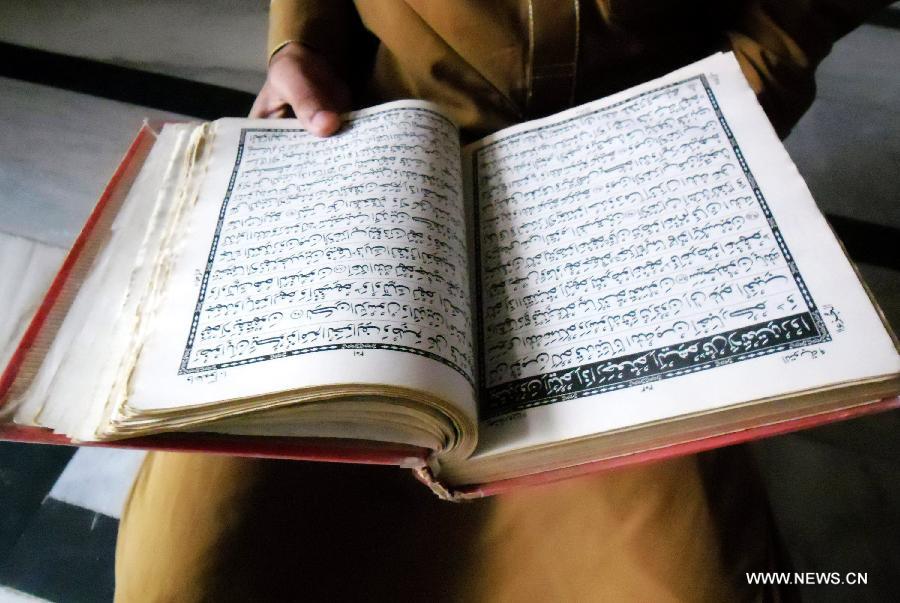 A Pakistani Muslim boy reads the holy book of Quran during Muslims fasting month of Ramadan at a mosque in northwest Pakistan's Peshawar on June 24, 2015. 