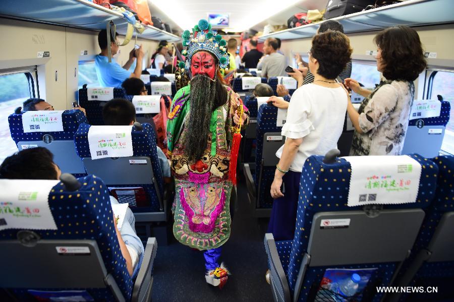 Little actors and actresses of Hui Opera walk to board the G306 high-speed train from Fuzhou to Beijing at the Jixi North Railway Station in Jixi County, east China's Anhui Province, June 28, 2015.