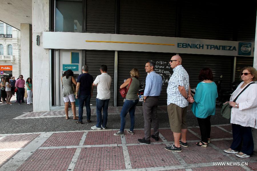 People line up at an ATM outside a National Bank branch in Athens, capital of Greece, on June 29, 2015.