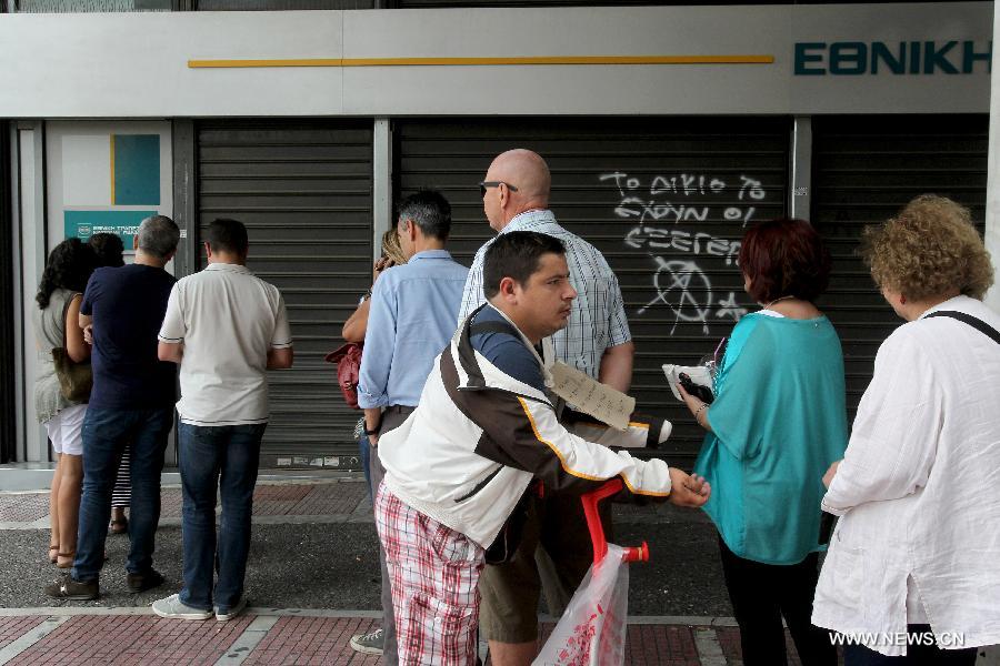 People line up at an ATM outside a National bank branch in Athens, June 29, 2015.