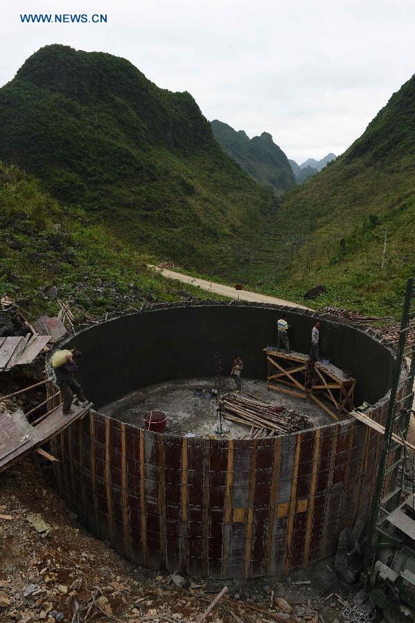 Workers build a 300-cubic-meter water tank to ease water shortage in Nongyong Village of Dahua Yao Autonomous County, south China's Guangxi Zhuang Autonomous Region, May 5, 2015. 