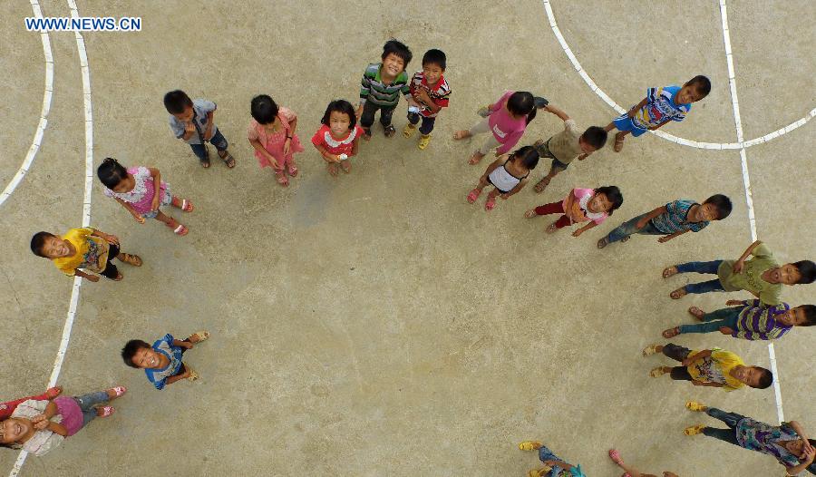 Children of Nongyong Village play on a ground at Nongyong Elementary School in Dahua Yao Autonomous County, south China's Guangxi Zhuang Autonomous Region, June 29, 2015.