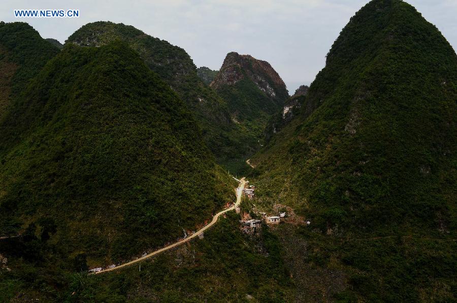 Villagers of Nongyong Village build a house along a road in Dahua Yao Autonomous County, south China's Guangxi Zhuang Autonomous Region, May 12, 2015.