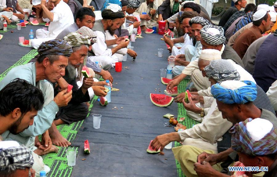 Afghans eat watermelon to break their fast during the holy month of Ramadan at a mosque in Balkh Province, north Afghanistan, July 1, 2015.