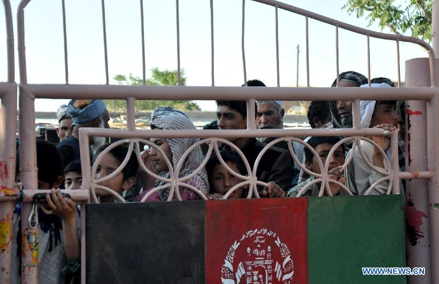 Afghan people wait to receive food during the holy month of Ramadan in Jawzjan province, northern Afghanistan, July 2, 2015.