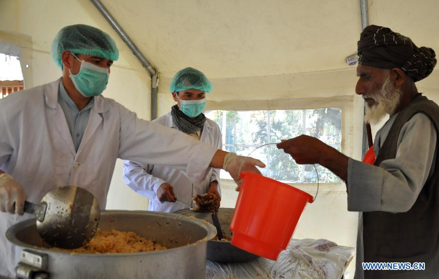 An Afghan man receives food donated by local people during the holy month of Ramadan in Jawzjan province, northern Afghanistan, July 2, 2015. 