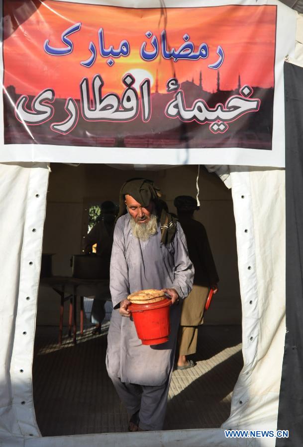 An Afghan man carries food donated by local people during the holy month of Ramadan in Jawzjan province, northern Afghanistan, July 2, 2015.