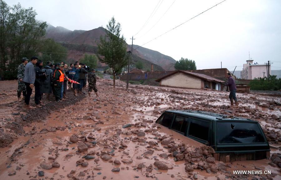 A car is in the mud in Hongsiwan Town of Sunan County, northwest China's Gansu Province, July 4, 2015.