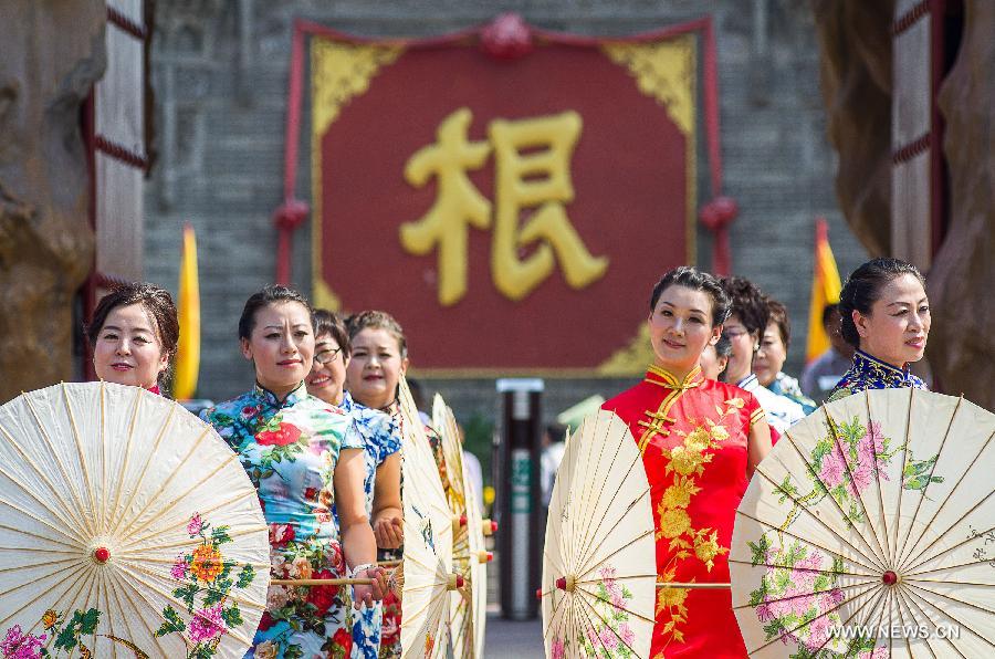 Models present cheong-sam creations during a commonweal activity at the Dahuaishu scenic zone in Hongtong County, north China's Shanxi Province, July 4, 2015. 