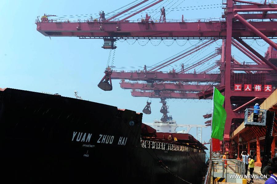 Cranes unload iron ore from 'Yuan Zhuo Hai', one of the world largest ore ships, at Dongjiakou dock in Qingdao, east China's Shandong Province, July 4, 2015. 