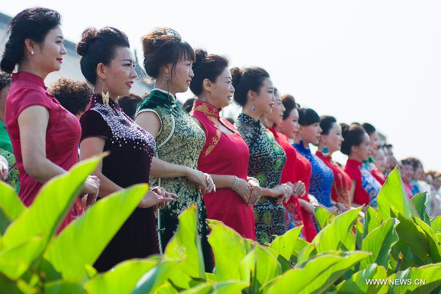 Models present cheong-sam creations during a commonweal activity at the Dahuaishu scenic zone in Hongtong County, north China's Shanxi Province, July 4, 2015. 