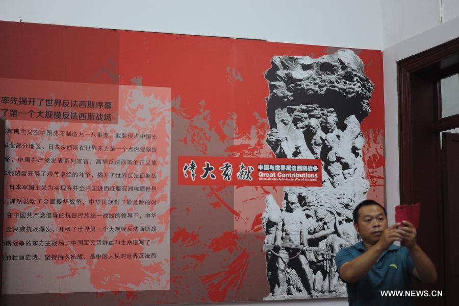 Visitors view a photo exhibition commemorating the 70th anniversary of the victory of the Chinese People's War of Resistance against Japanese Aggression at the former Japanese consulate in Zhengzhou, capital of central China's Henan Province, July 8, 2015.