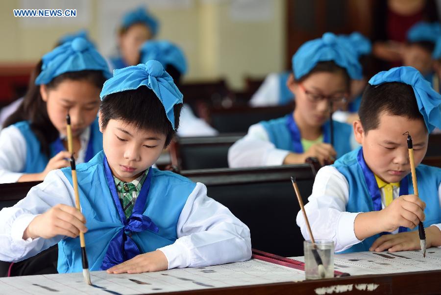 Children practise calligraphy in a summer class provided free of charge by a community in Hefei, capital of east China's Anhui Province, July 9, 2015. 