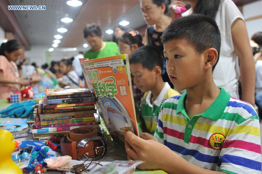 A boy reads a book when cooling off at a bomb shelter in Chongqing, southwest China, July 9, 2015.