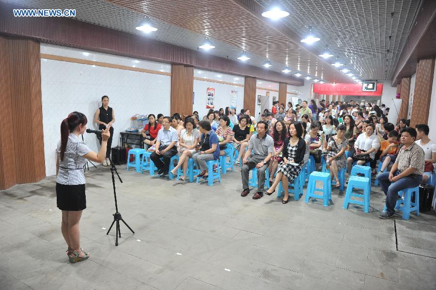 People share stories when cooling off at a bomb shelter in Chongqing, southwest China, July 9, 2015.