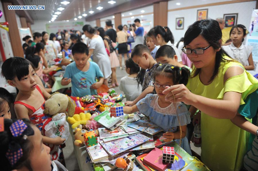 Citizens do their shopping at a flea market when cooling off at a bomb shelter in Chongqing, southwest China, July 9, 2015.