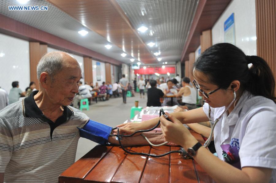 A man has his blood pressure measured when cooling off at a bomb shelter in Chongqing, southwest China, July 9, 2015. 