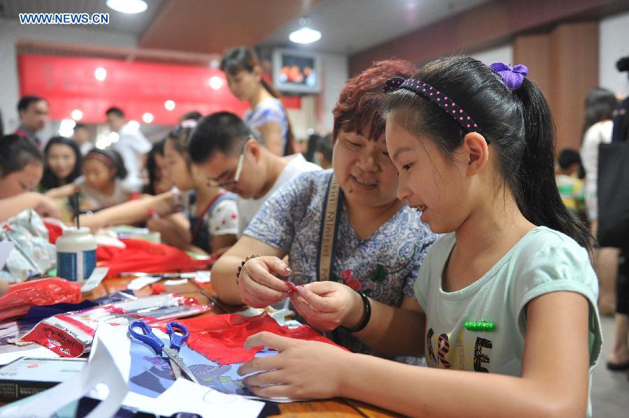 A girl makes handicraft when cooling off at a bomb shelter in Chongqing, southwest China, July 9, 2015.