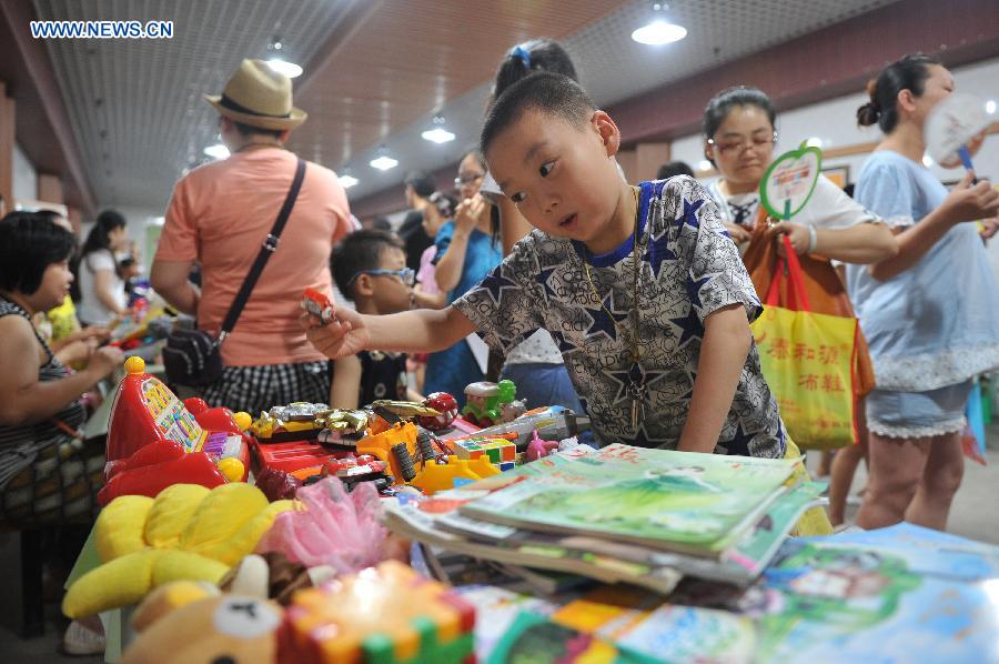 Citizens do their shopping at a flea market when cooling off at a bomb shelter in Chongqing, southwest China, July 9, 2015. 