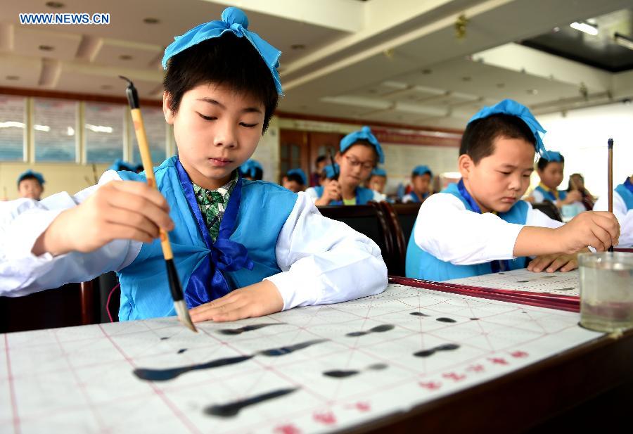 Children practise calligraphy in a summer class provided free of charge by a community in Hefei, capital of east China's Anhui Province, July 9, 2015.