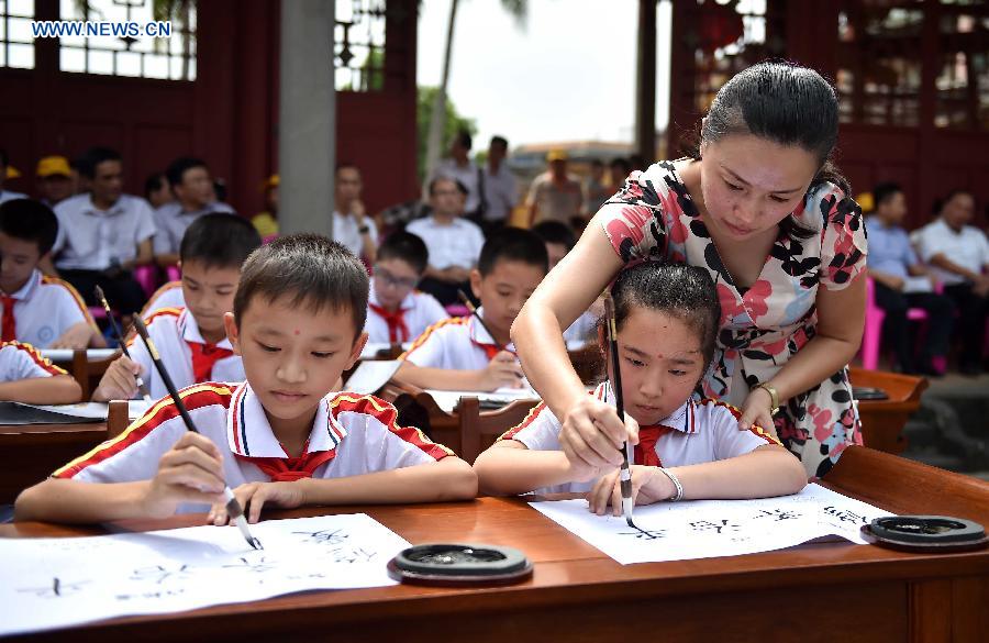 Students write with traditional brush pens at the Confucius classroom in the Confucius temple of Wenchang, south China's Hainan Province, July 10, 2015.