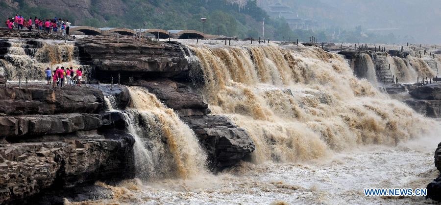 People gather to watch the Hukou Waterfall on the Yellow River in Linfen, north China's Shanxi Province, July 10, 2015. 