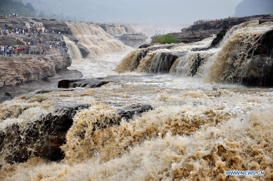 People gather to watch the Hukou Waterfall on the Yellow River in Linfen, north China's Shanxi Province, July 10, 2015.